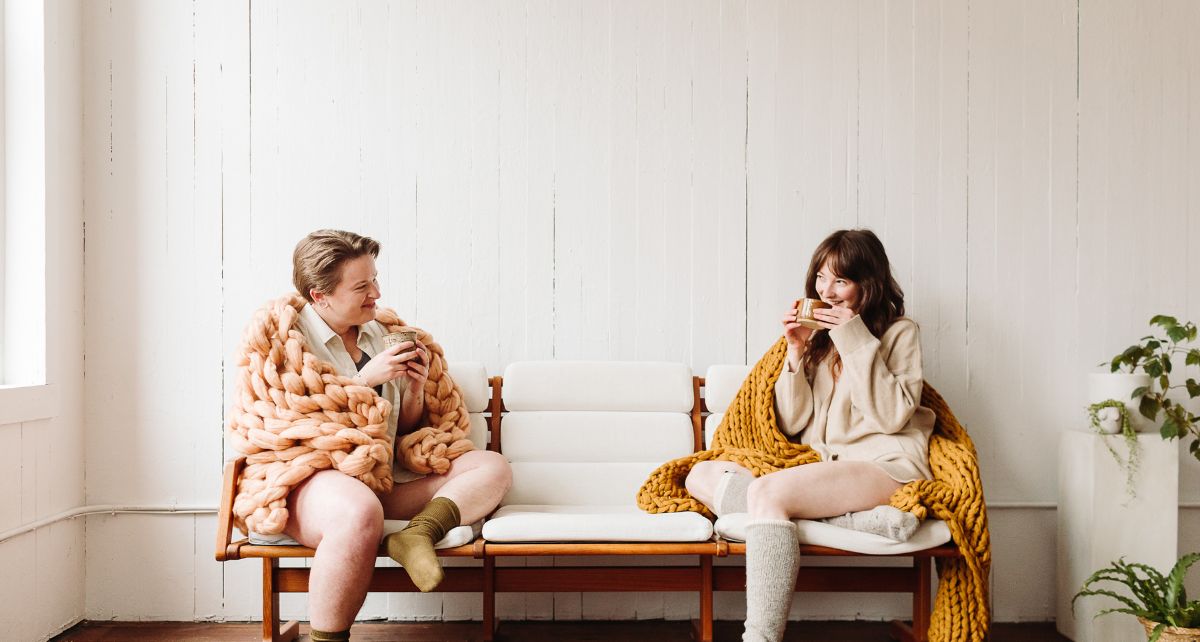 Two menstruators sit on a bench waiting at the gynecologist office