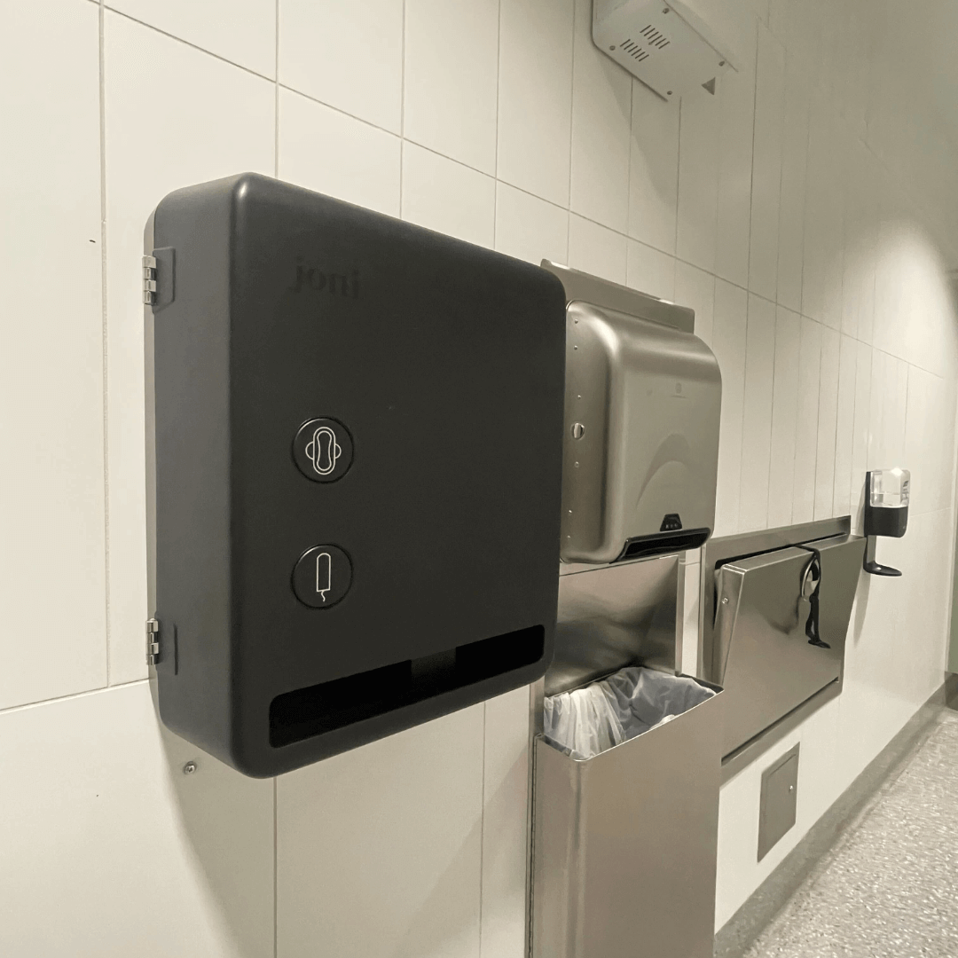 Smart Free-vend Period Care Dispenser Model V mounted on a restroom wall for touchless menstrual care access.
