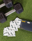 Bamboo incontinence pads by joni next to dumbbells on grass background, highlighting active lifestyle and leak protection.