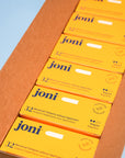 Open casepack of joni regular tampons for commercial washrooms with a blue background