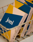 Basket of joni Mini Period Pad Packs with vibrant blue and yellow packaging for eco-friendly menstrual care.