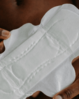 joni regular pad unwrapped and help open to show high quality and soft texture of period pad
