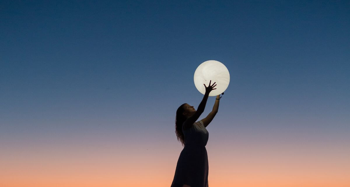 Woman holds the moon in her hands