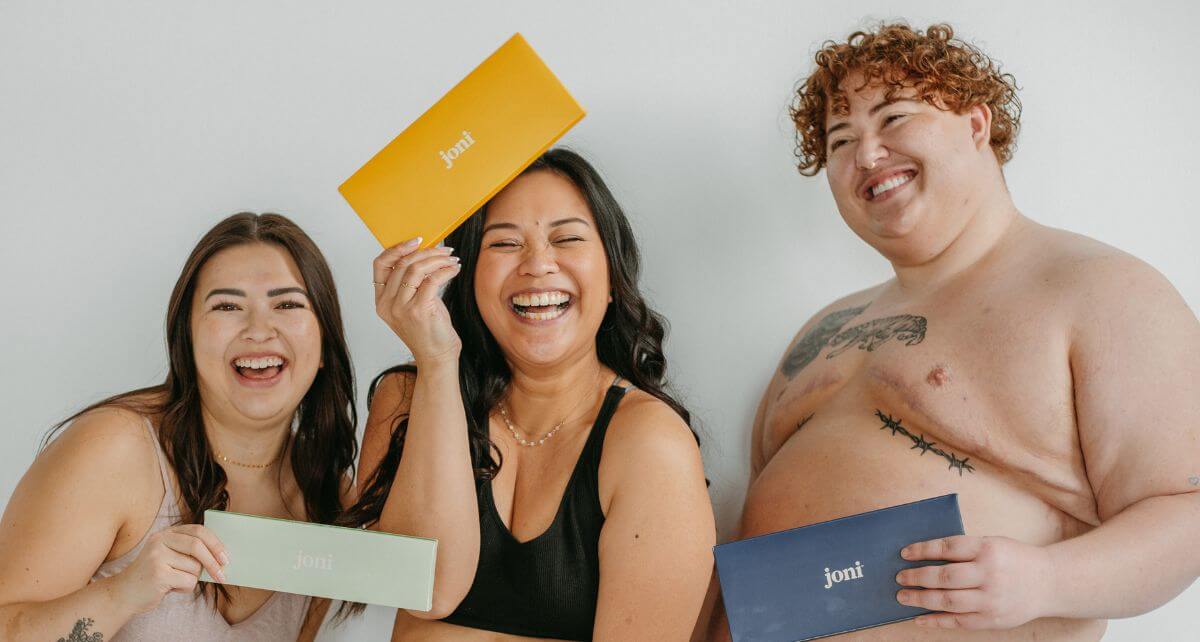 Two woman and trans man holding joni period care