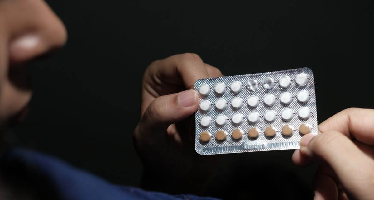 Person holds a pack of birth control pills
