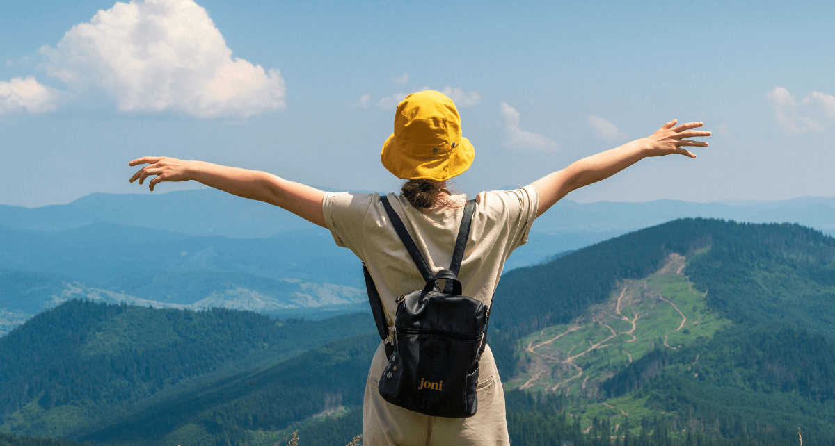 Woman on period hiking and looking at mountain scenery
