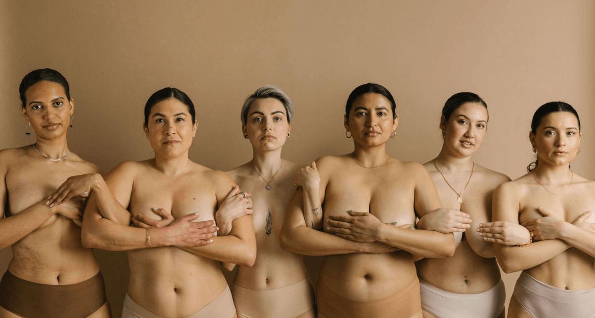 Group of diverse women standing together, representing menstrual cycle and breast health awareness.