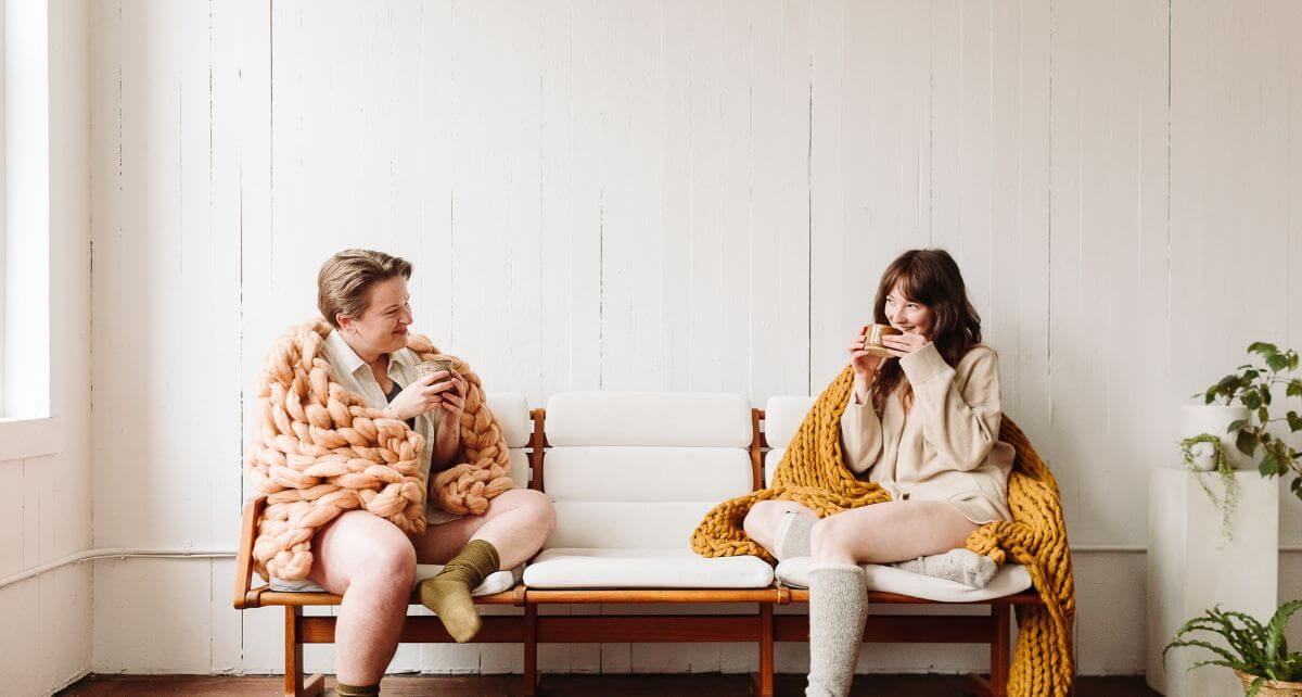 Two menstruators sit on a bench waiting at the gynecologist office