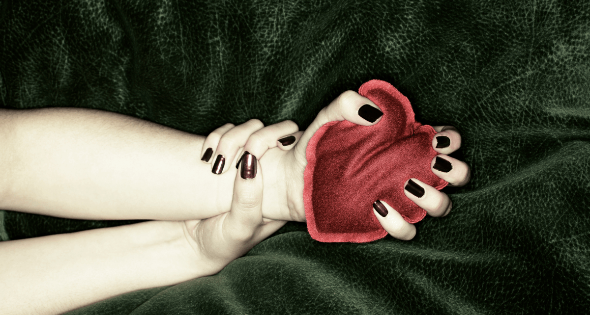 Signs of endometriosis illustrated by a hand holding a hot water bottle for relief on a cozy surface.