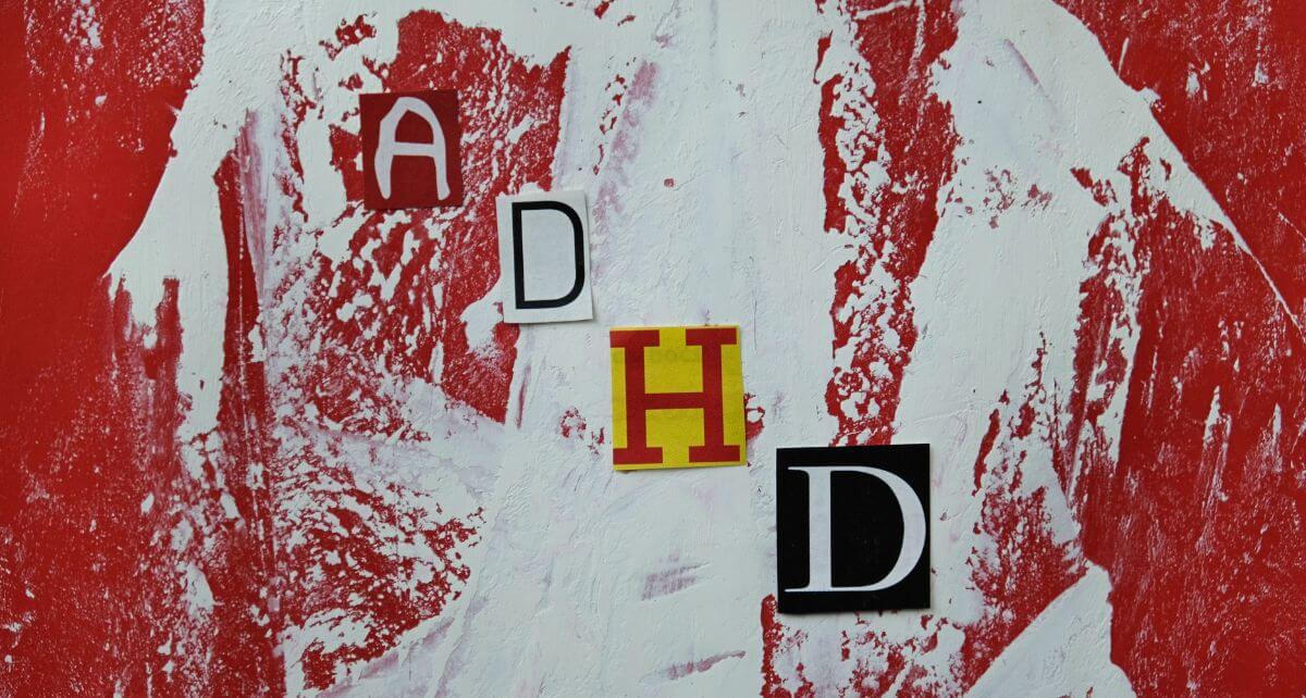 Artistic representation of ADHD with red and white background and letters A, H, D in different fonts.
