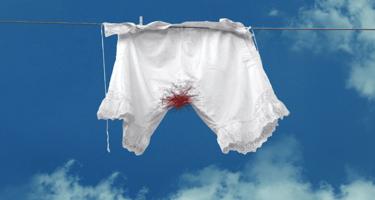 A pair of old fashioned bloomers hang on a laundry line with period stains representing period stigma past and present