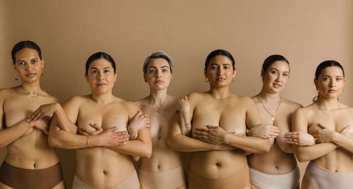 Group of diverse women standing together, representing menstrual cycle and breast health awareness.