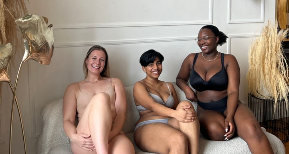 Three menstruators on a couch in their underwear sharing period stories