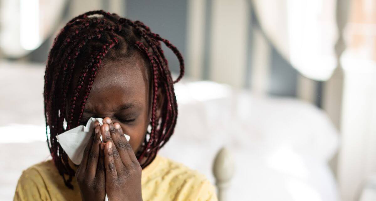 Woman catches her sneeze with a tissue