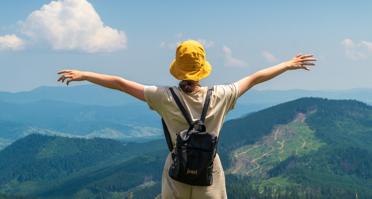 Woman on period hiking and looking at mountain scenery