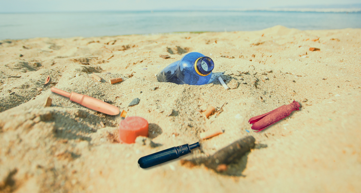 Plastic tampon applicators and a plastic bottle litter the beach by the ocean