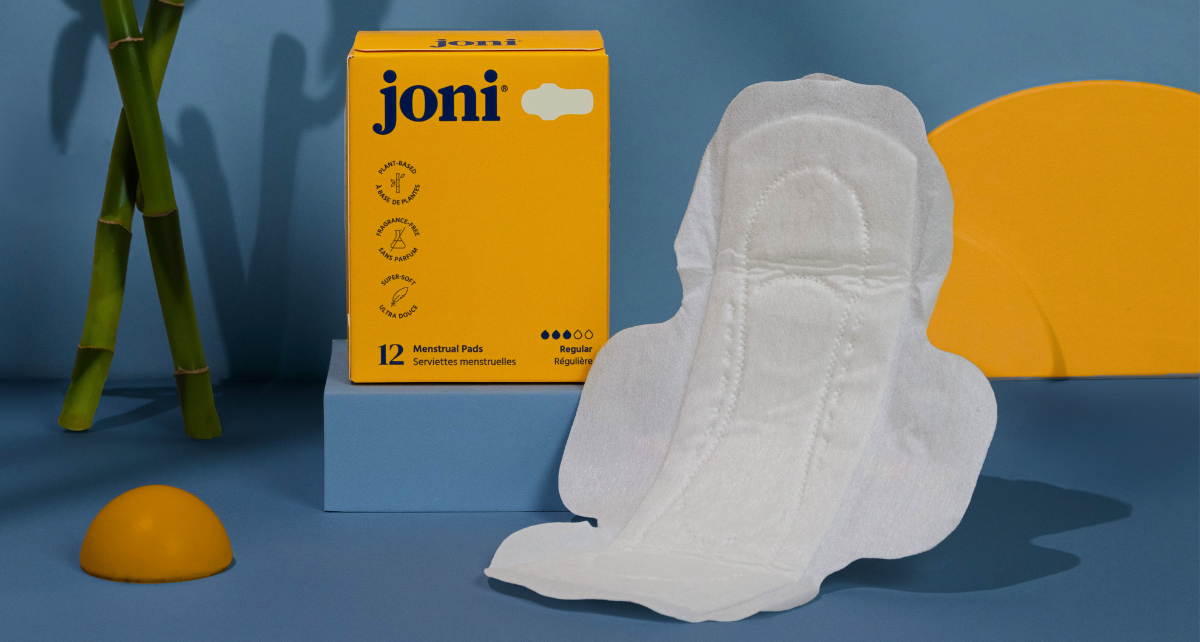 A joni retail box of regular pads with a blue background and sticks of bamboo and one regular pad unwrapped