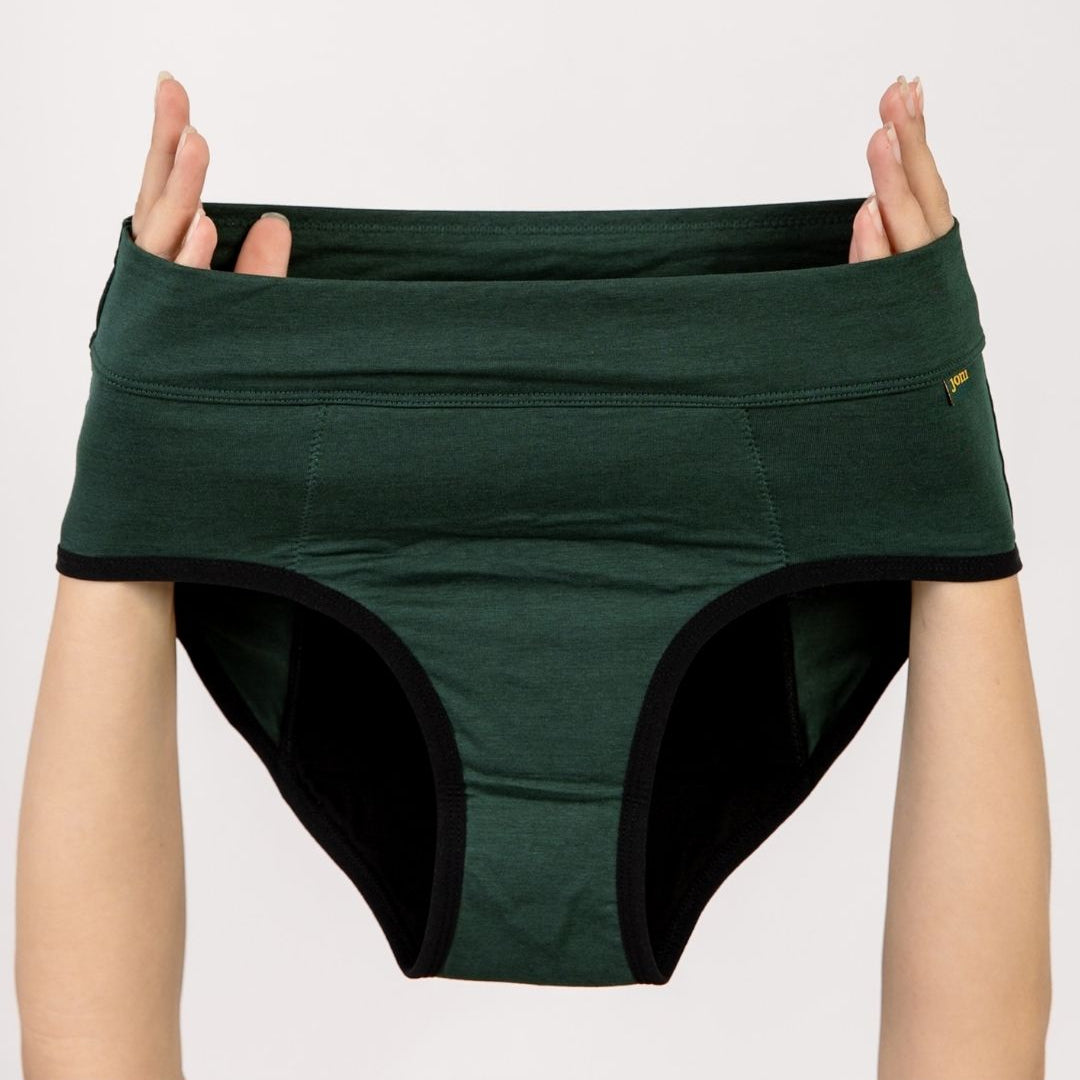 Dark green joni high-waisted leakproof period underwear  briefs held up by a person's hands against a plain light background.