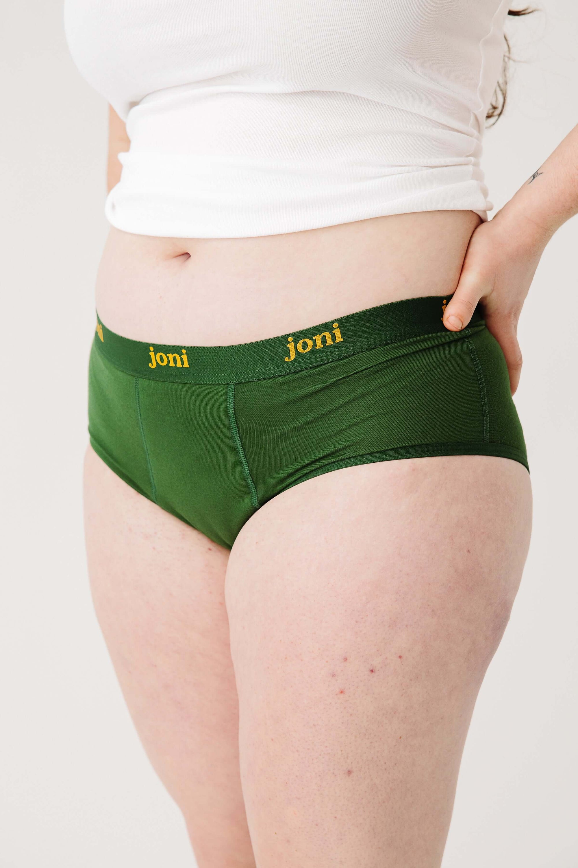 Green period underwear with 'joni' branding worn by a person on a white background