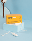 Joni tampons and packaging on a light blue background